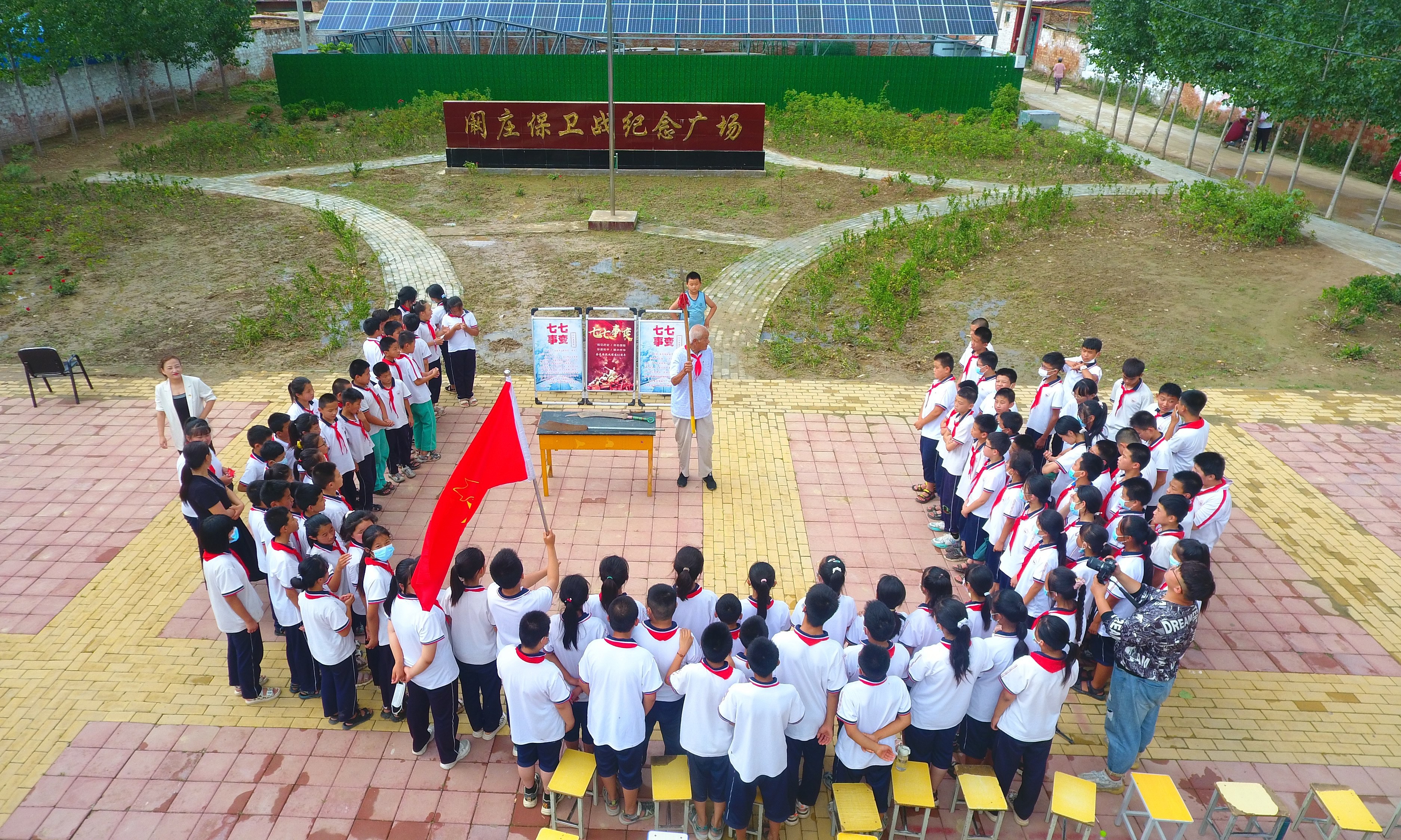 2022年7月6日，山東省聊城市，在茌平區(qū)菜屯鎮(zhèn)闞莊村的闞莊保衛(wèi)戰(zhàn)紀念廣場，闞莊保衛(wèi)戰(zhàn)親歷者王光木老人，為小學生們講述抗戰(zhàn)故事，展示大刀、長矛。